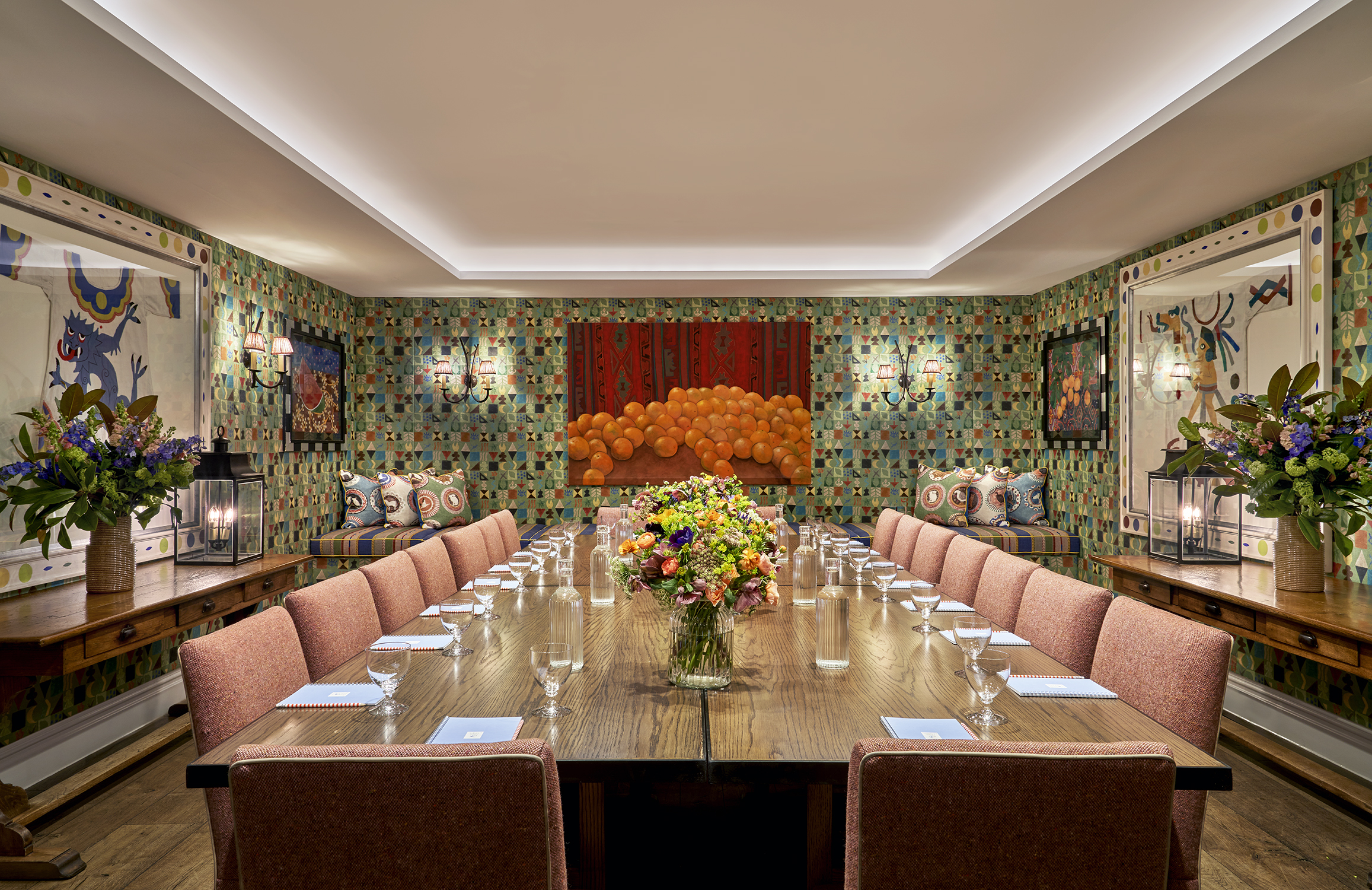 A squared meeting table set-up with notepad and glass of water in the Vanessa Bell private events room at Charlotte Street Hotel