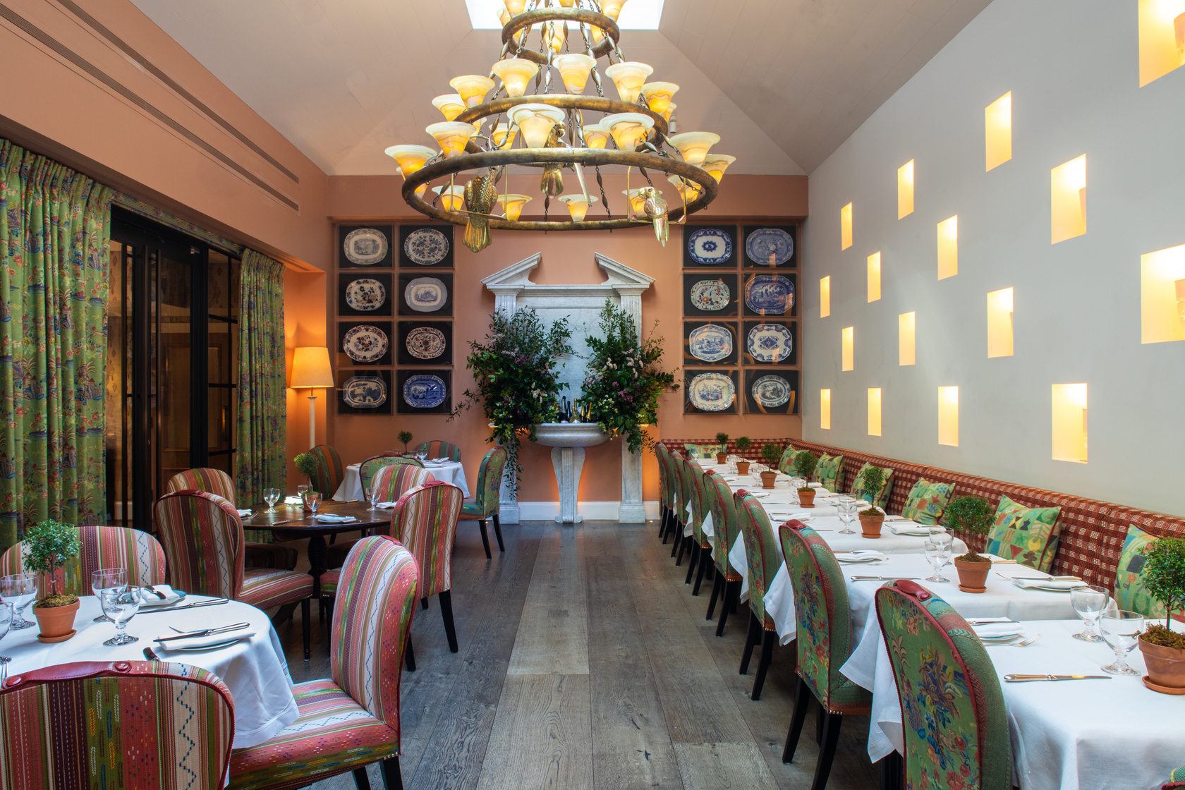 Wide shot of square and round dining tables set-up in the Orangery private events room at the Whitby Hotel