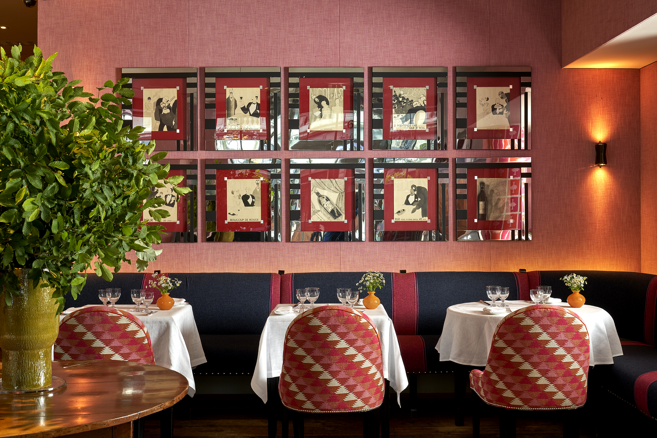 Side shot of Brumus Restaurant dining tables and artwork at Haymarket Hotel