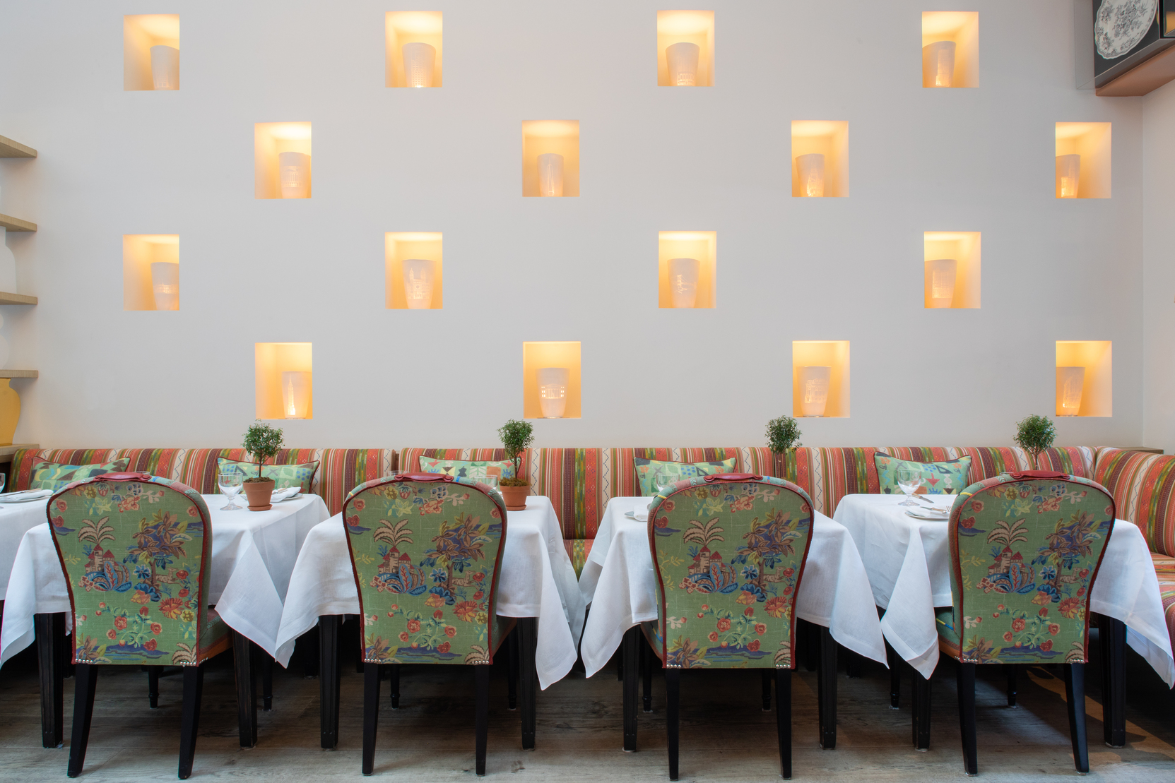 Close up image of dining tables set-up against the wall with art installation in The Orangery private events room at the Whitby Hotel.