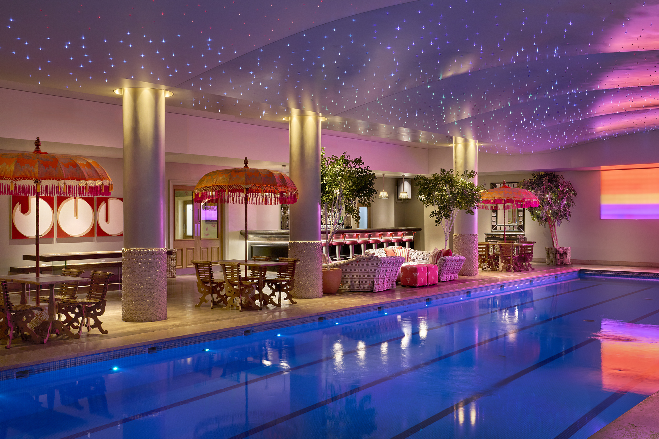 A diagonal shot of the swimming pool and bar at Haymarket Hotel looking across to the pool bar area