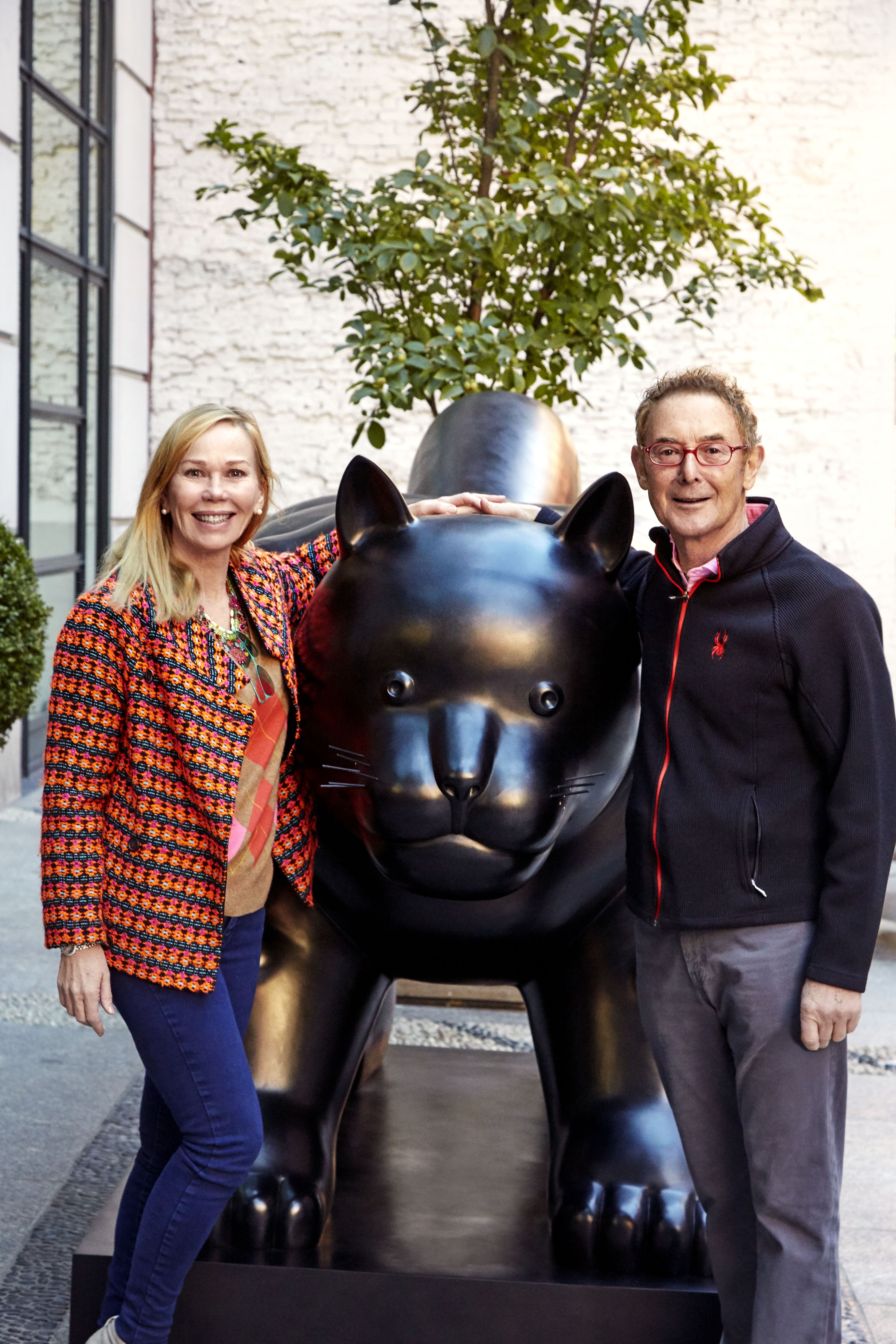 This image shows Kit and Tim Kemp standing next the Botero Cat statue that sits outside Warren Street Hotel in New York. Kit stands on the left smiling with Tim on the right of the statue smiling.