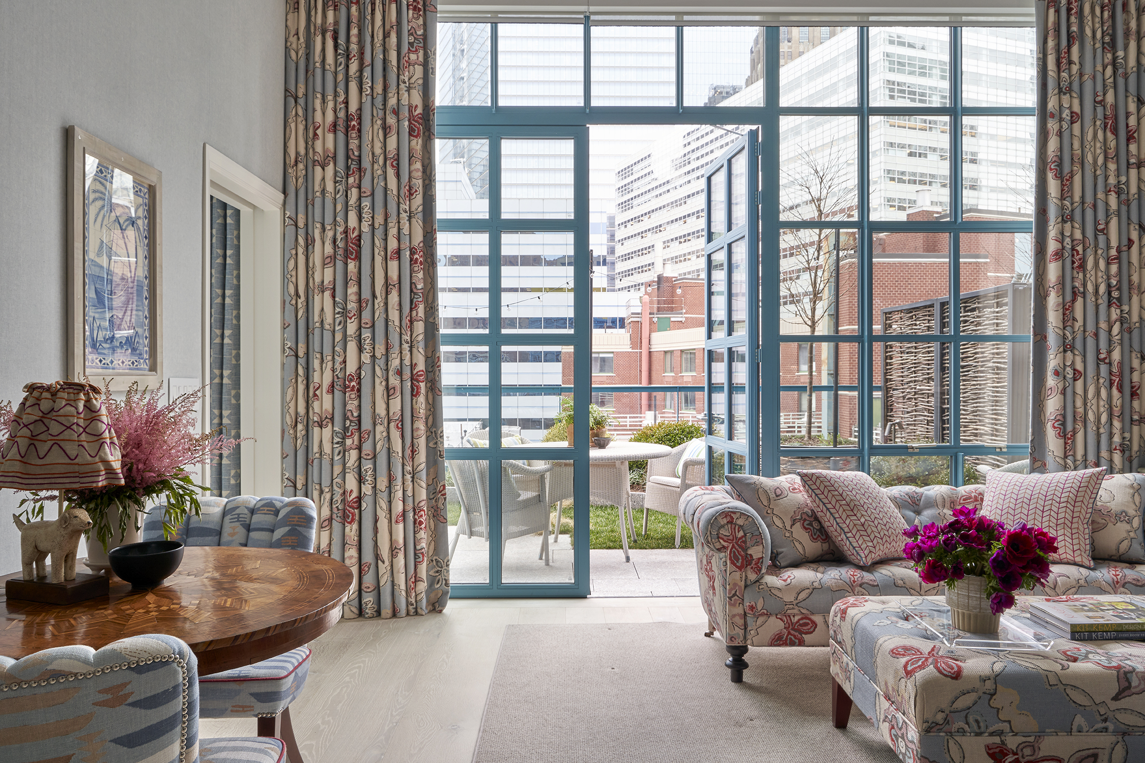 A wide shot of the living room with doors opening onto a terrace in Two Bedroom Warren Terrace Suite at Warren Street Hotel