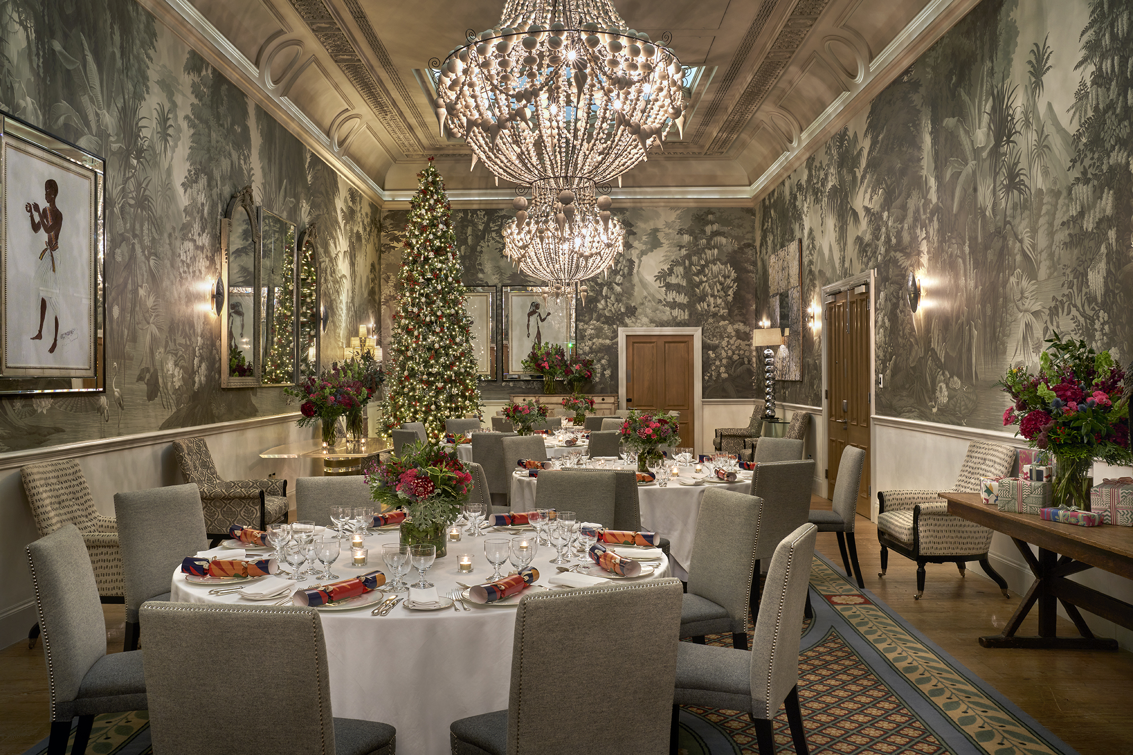 Shot of round dining festive tables and a Christmas tree in the Shooting Gallery at Haymarket Hotel