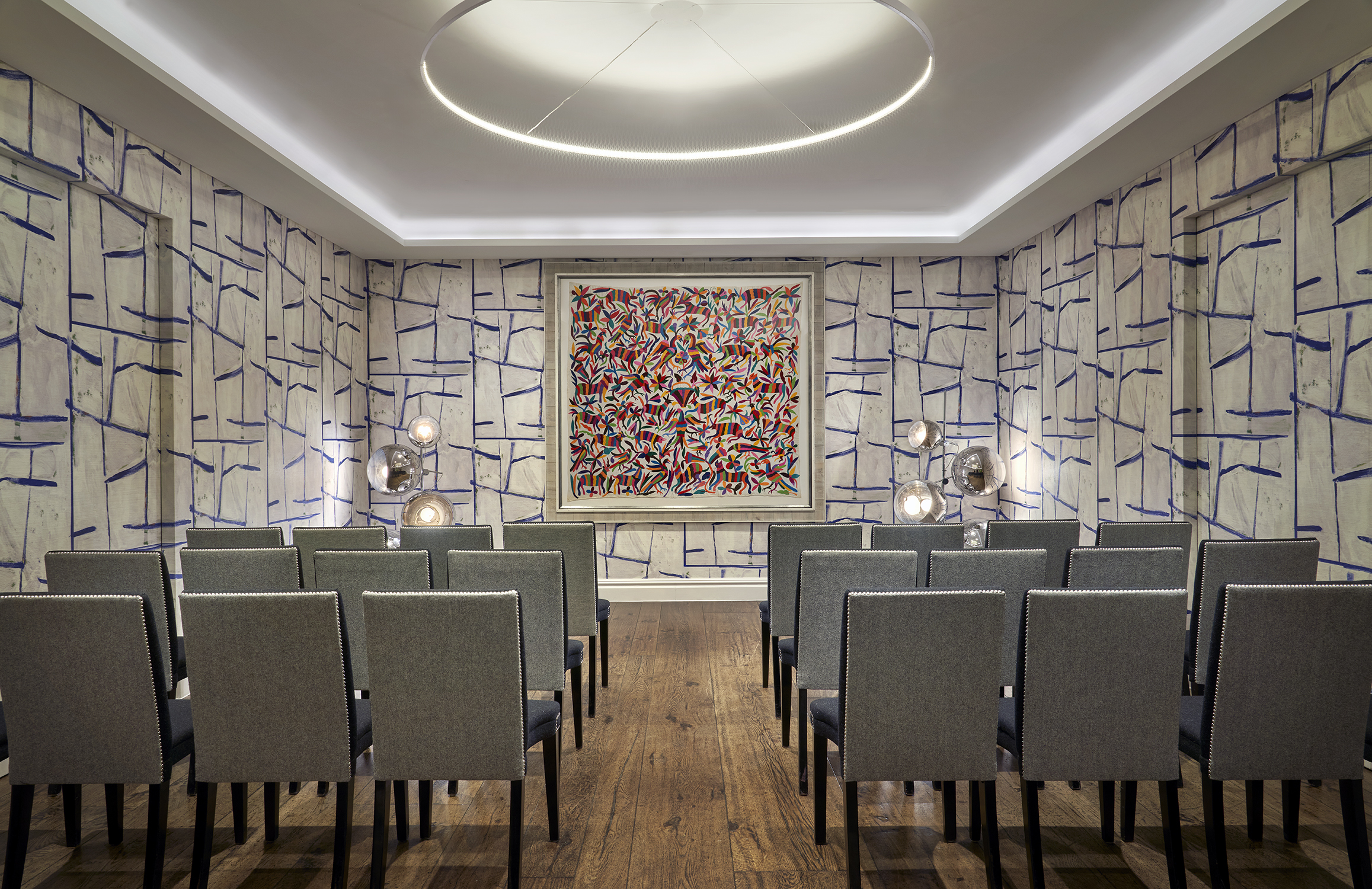 An image of the conference set up, with chairs in rows, in the Sandra Blow private event room, in The Soho Hotel. With 3 rows of 8 chairs across with a break in the middle creating an aisle.