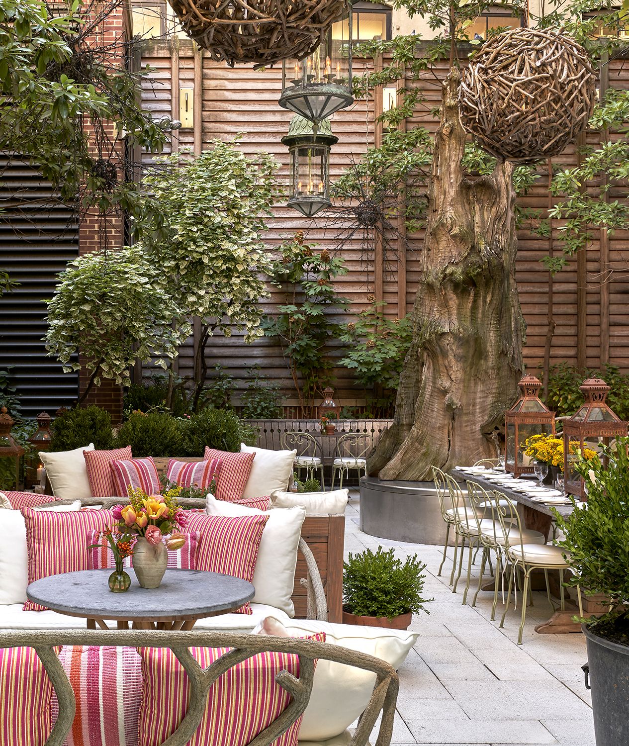 Portrait shot of the long dining table and seating areas in the Sculpture Garden at Crosby Street Hotel