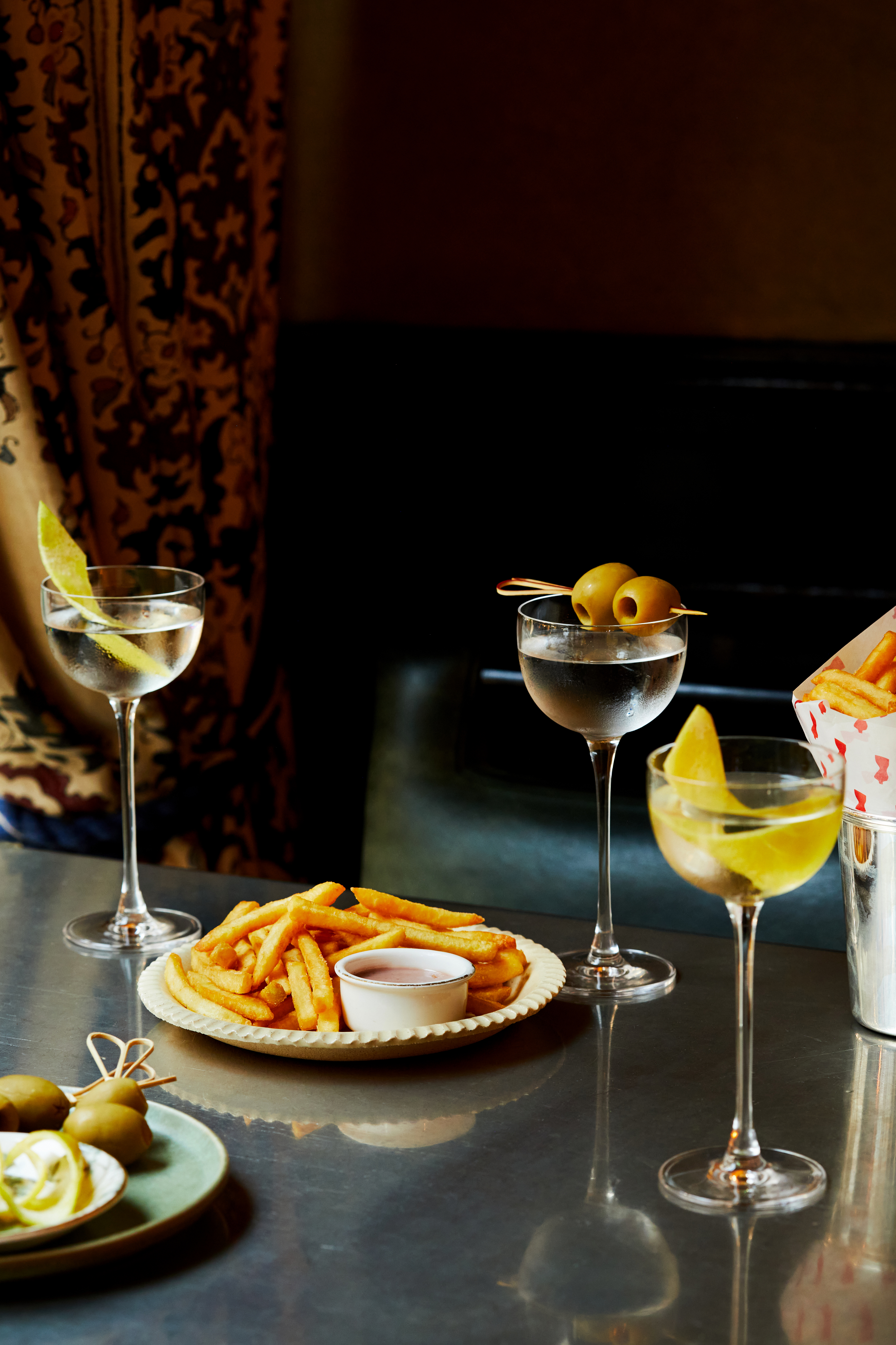 Martini Hour at Brasserie Max. A portrait shot of a table of martinis and fries on a table