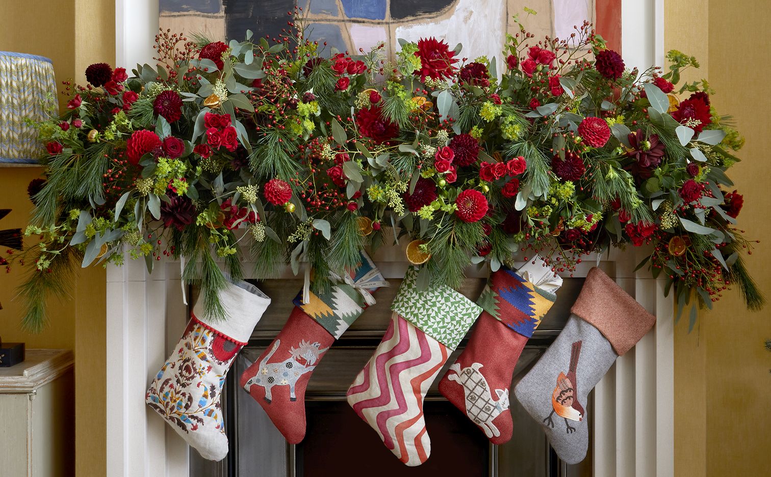 Firmdale festive stockings and Christmas decorations above a fireplace