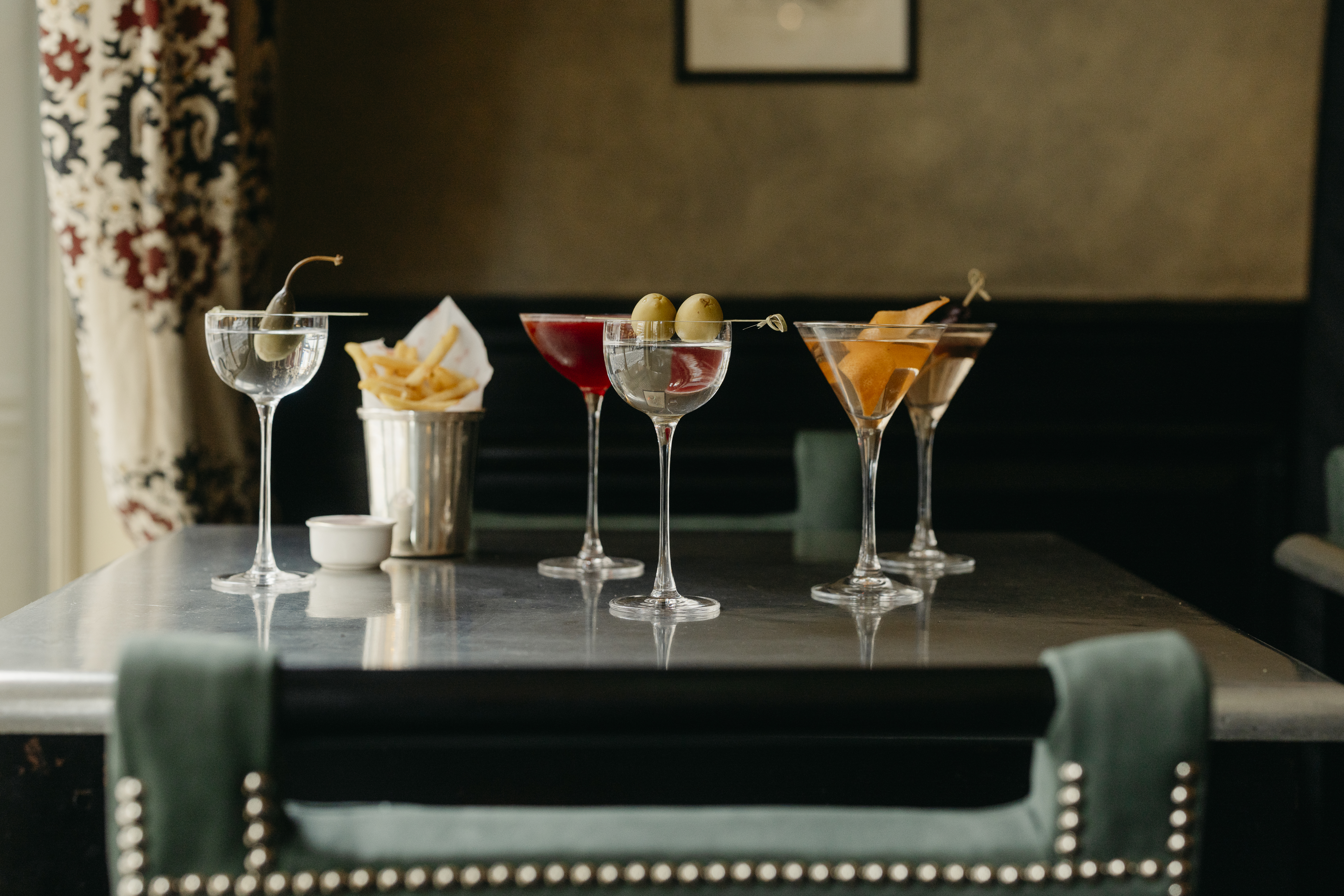 Wide shot of Martinis and bar snacks on a table at Brasserie Max