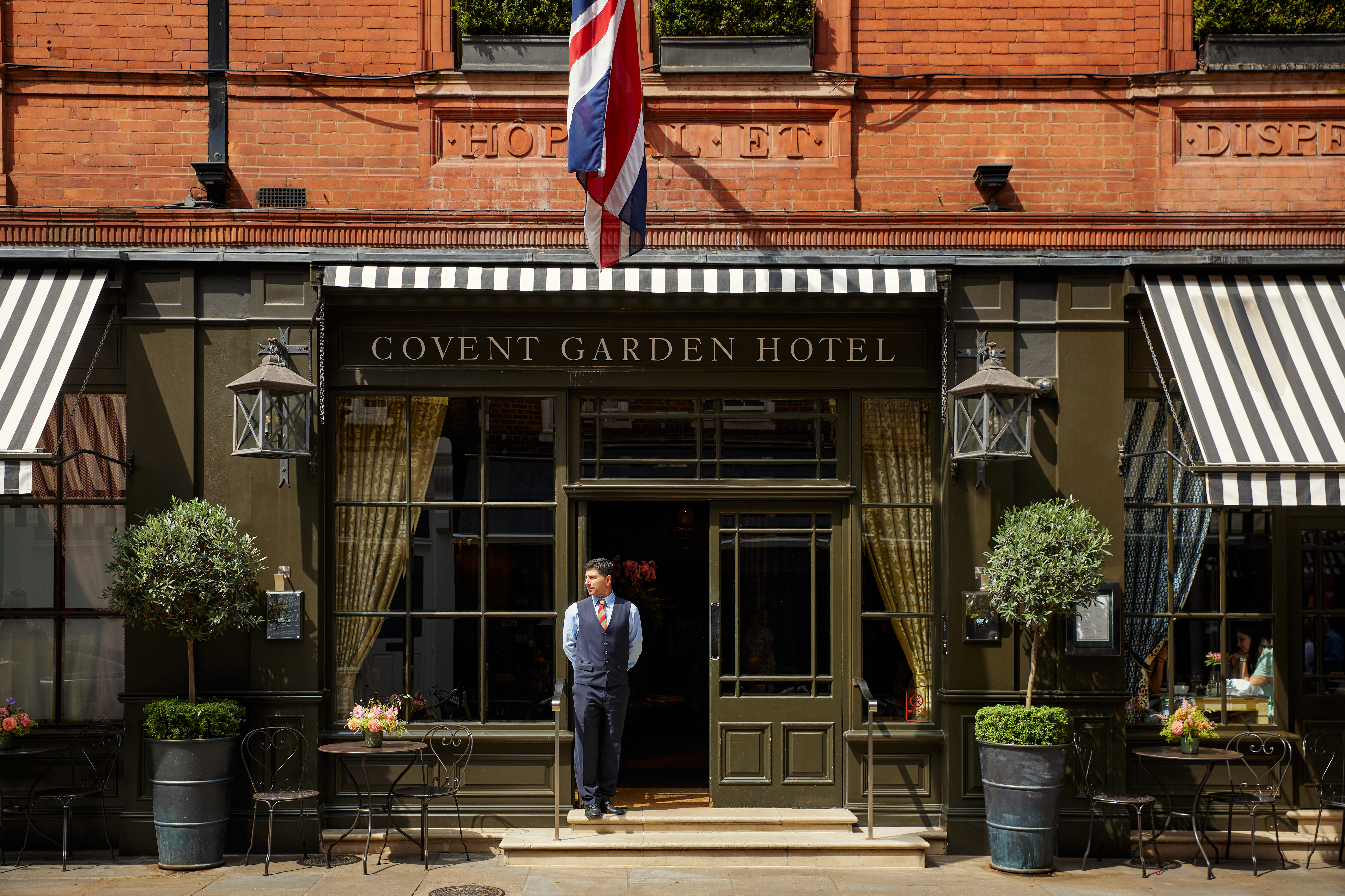 Front on exterior shot of Covent Garden Hotel with a doorman standing in the entrance