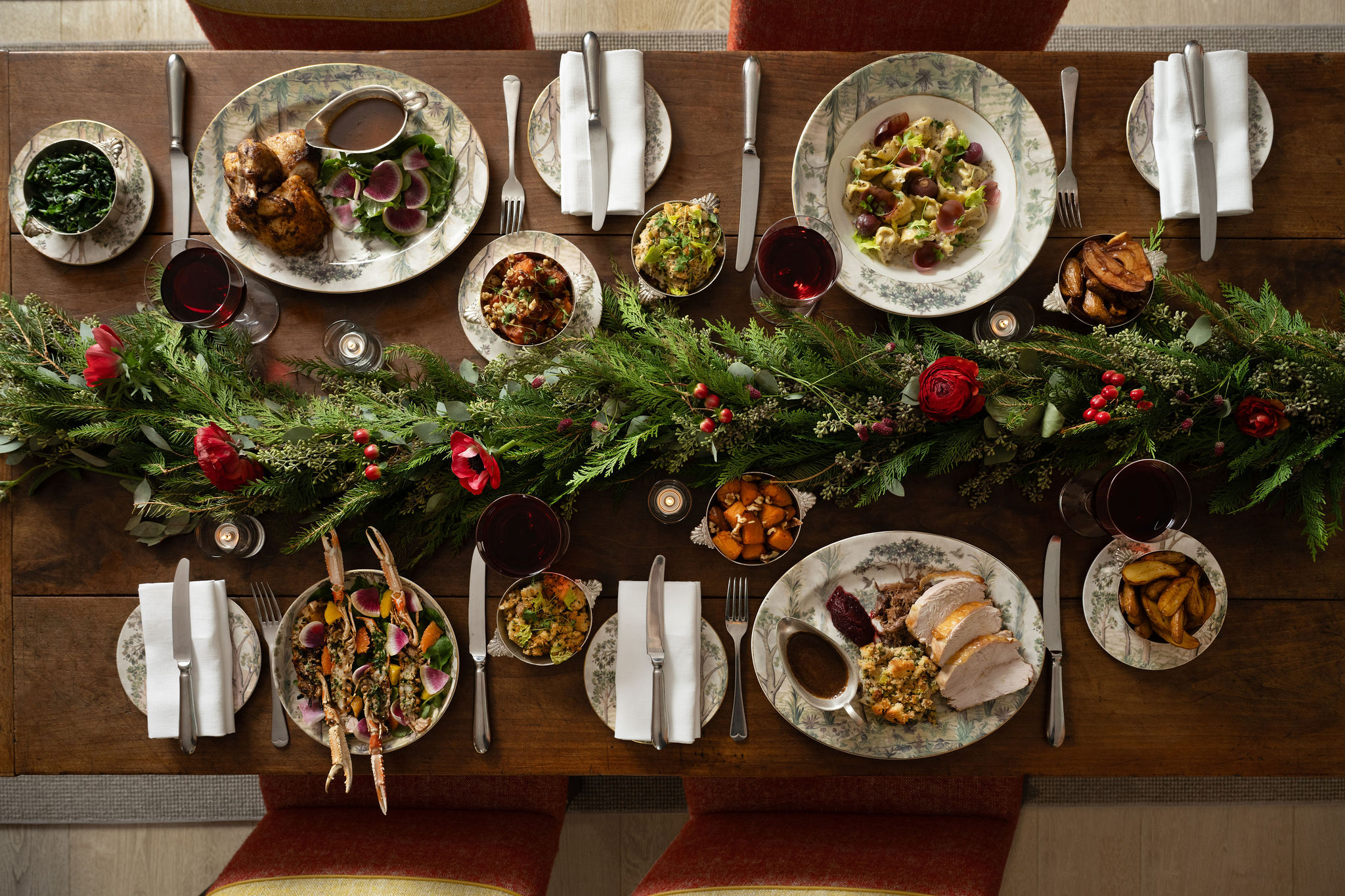 This a landscape image of a festive dining scene at the Warren Street Bar, Warren Street Hotel, featuring different dishes from the festive menu including a seasonal pasta dish and a traditional roast dinner served on Tall Tress Fine Bone China.