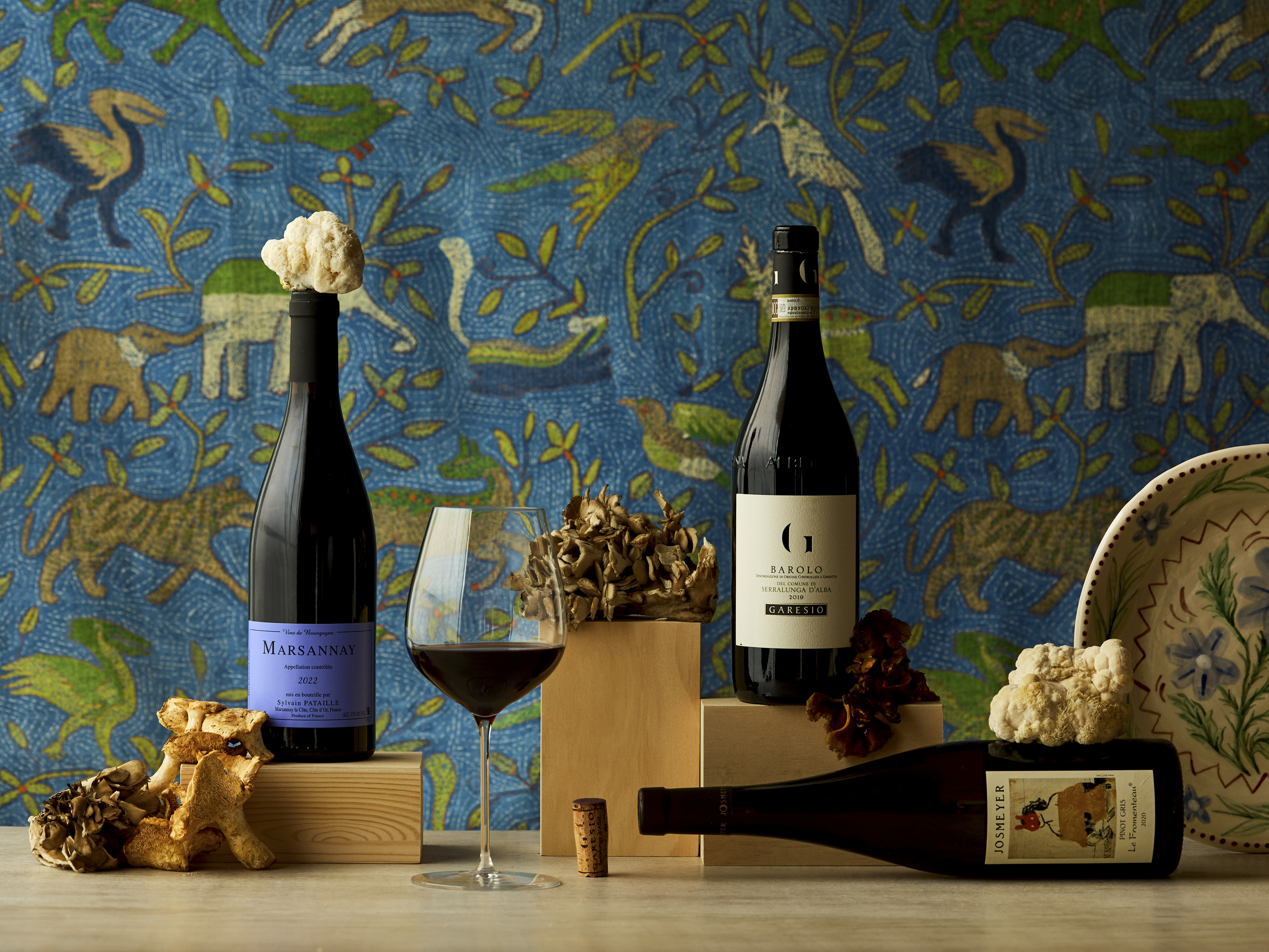 Wide shot of three bottles of wine on a table for Firmdales journal article about pairing wine with mushrooms.