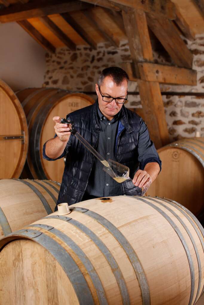 Benoit Dehu samples his Champagne from a wooden barrel