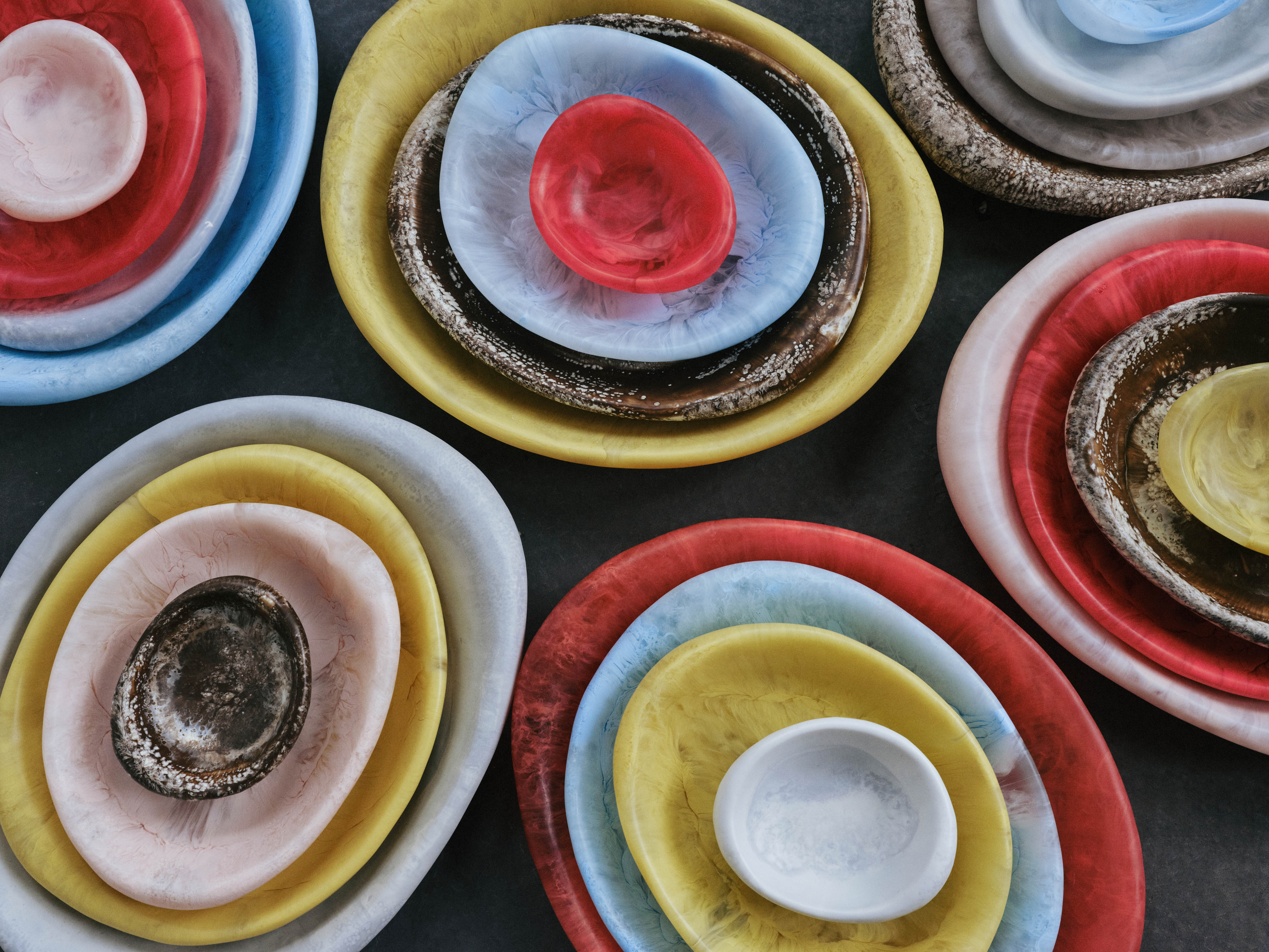 A shot from above of large colourful stone dishes of varying sizes grouped together from the Rock collection by Dinosaur Designs