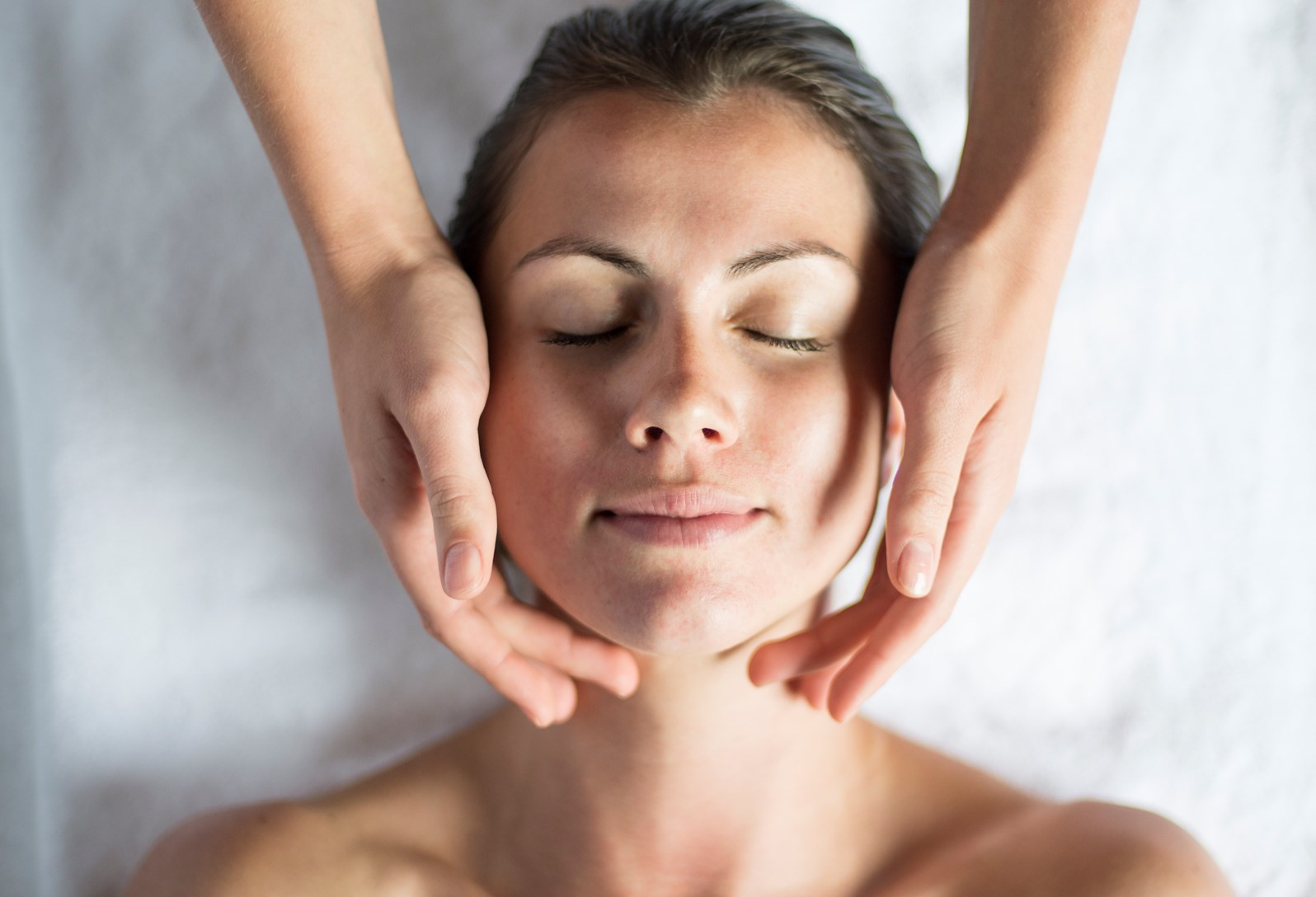 A lady is given a facial in a treatment room at Soholistic Spa at Ham Yard Hotel