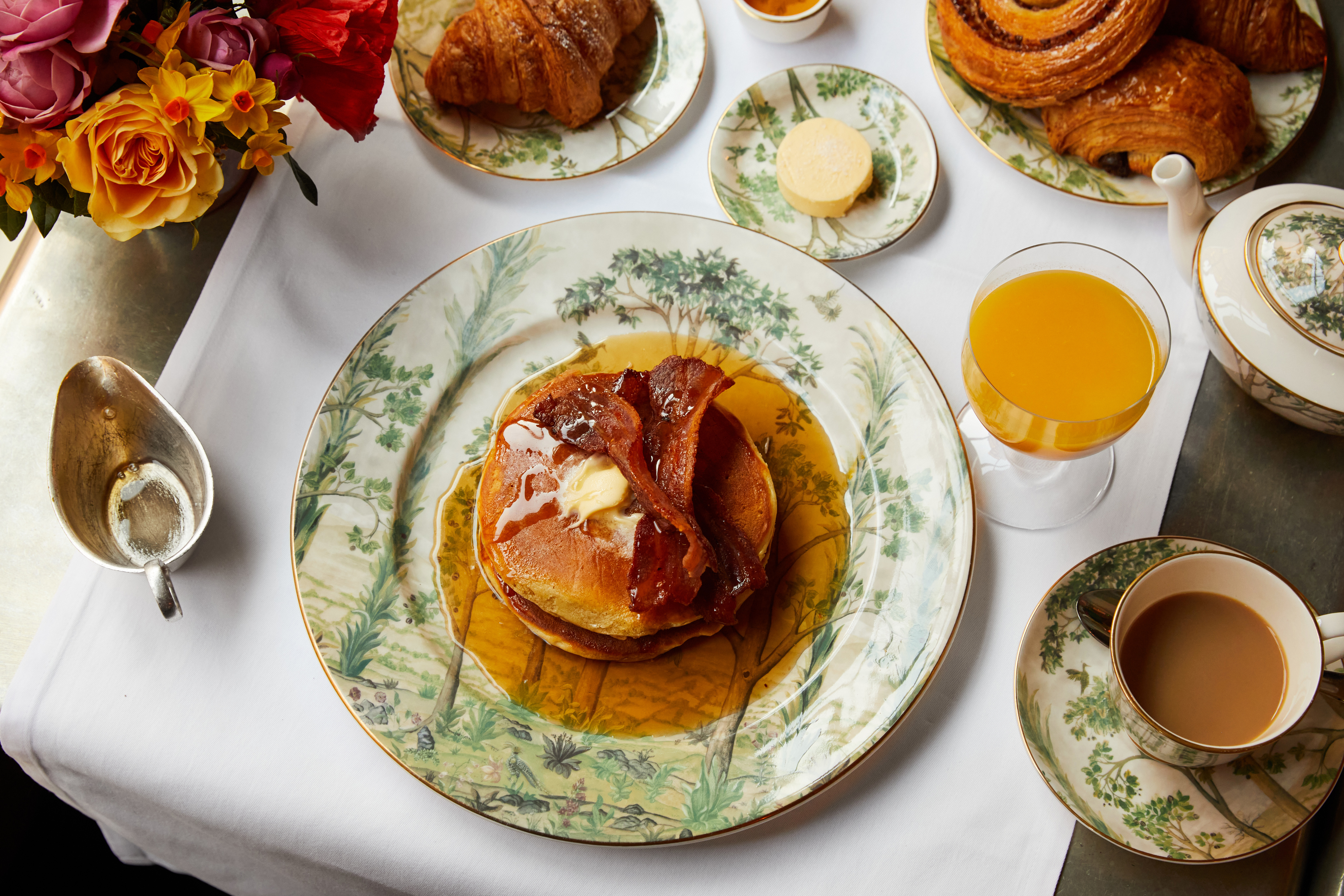 Breakfast at Brasserie Max. Plates of pancakes with bacon and a selection of pastries