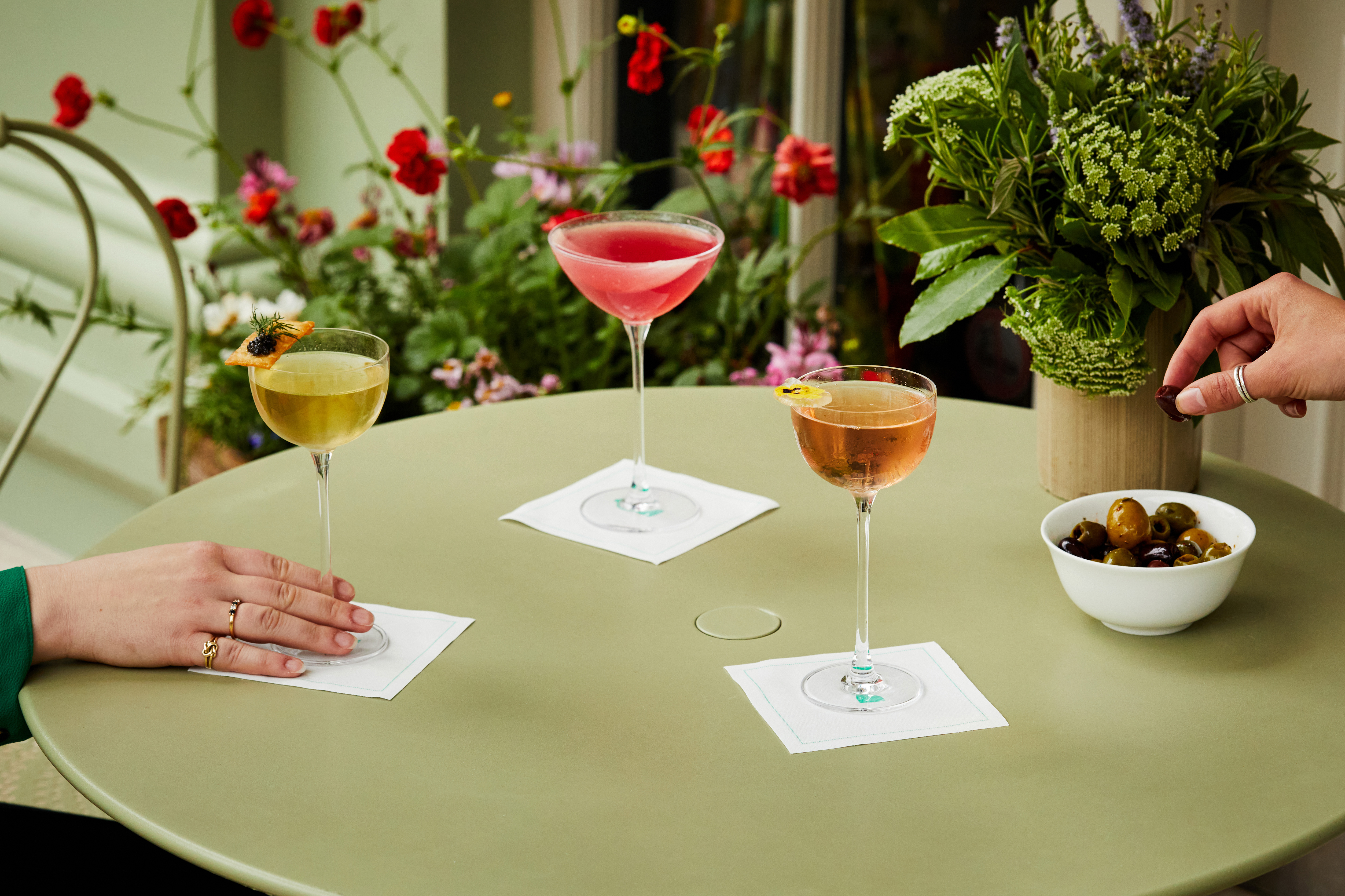 Wide shot of cocktails, bar snacks and guests on the terrace at Oscar