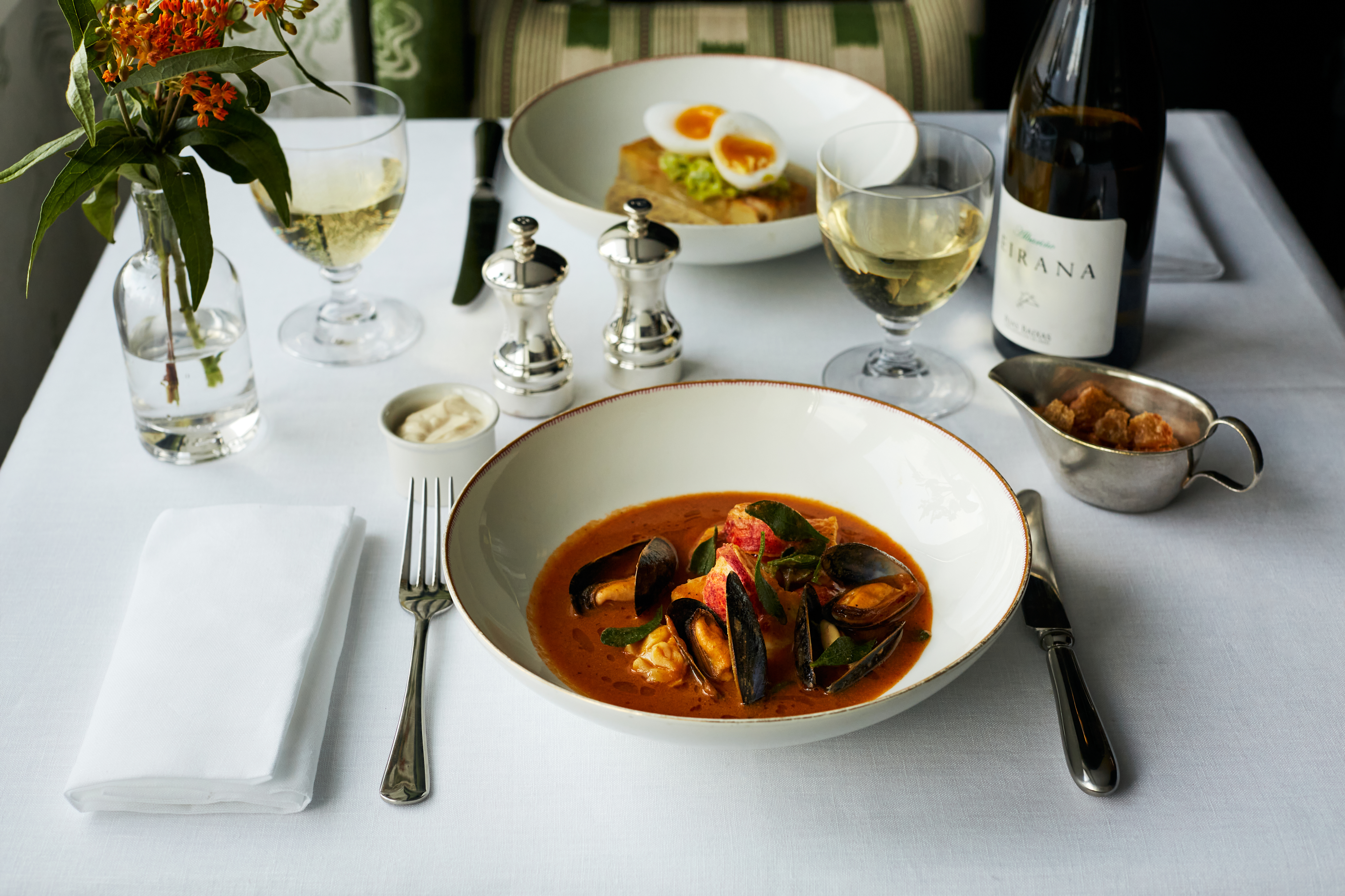 Close up shot of a main course of shellfish stew in a shallow bowl on a table at The Potting Shed