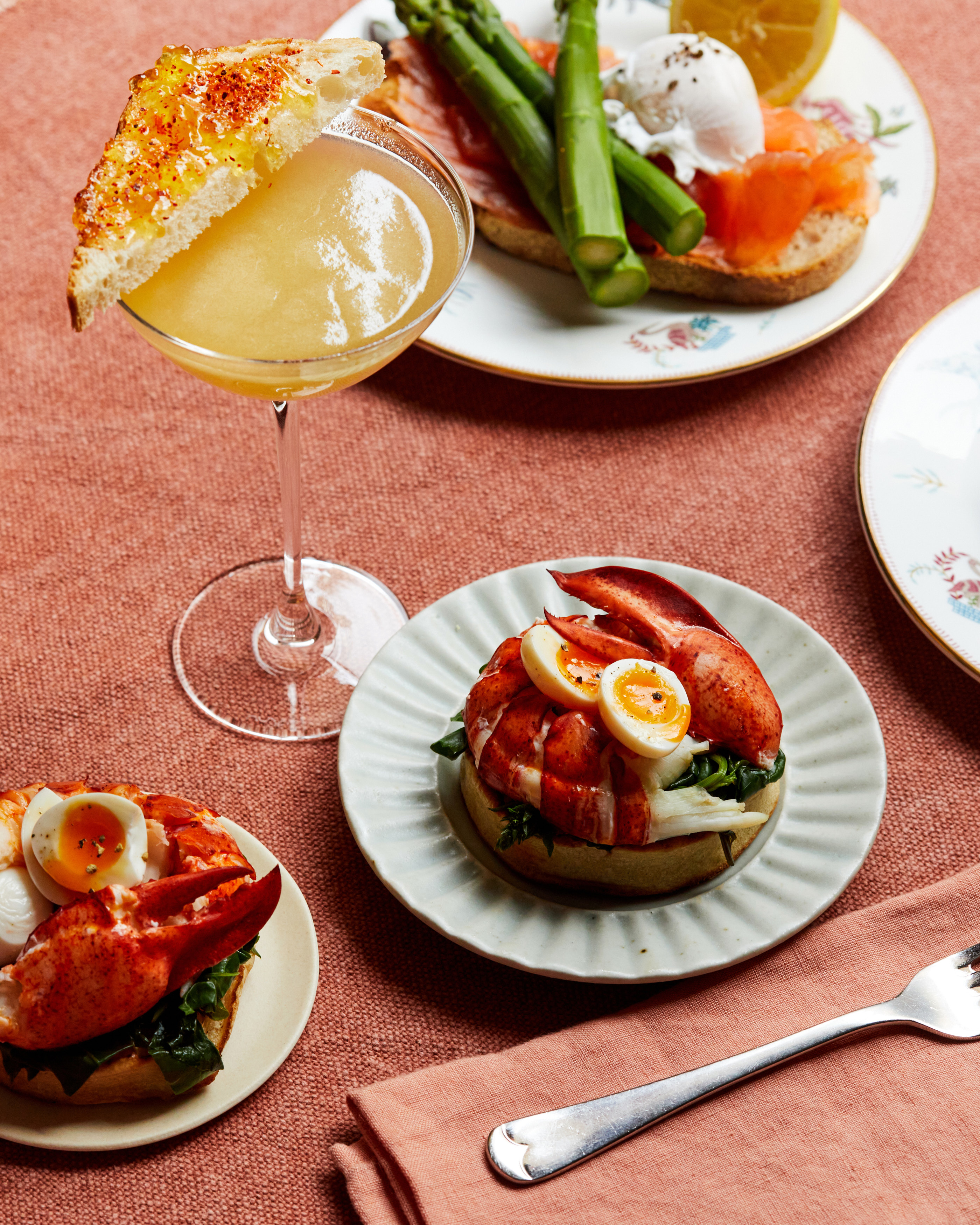 A close up image of the breakfast with Oscar cocktail and and the lobster with poached egg from the Oscar, Charlotte Street Hotel brunch menu.
