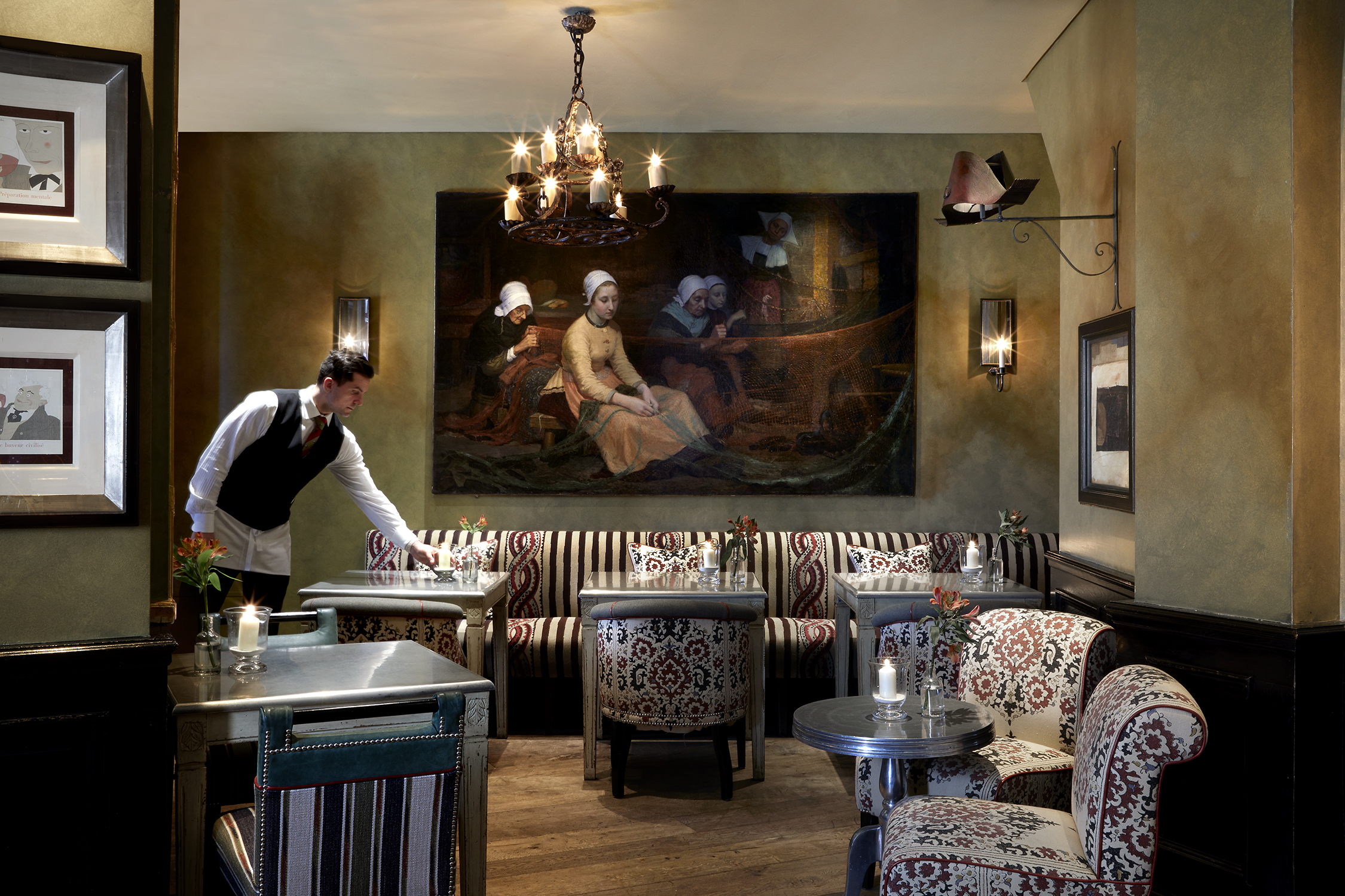 A corner shot of the bar area at Brasserie Max. On the left, a man can be seen placing a candle on a table