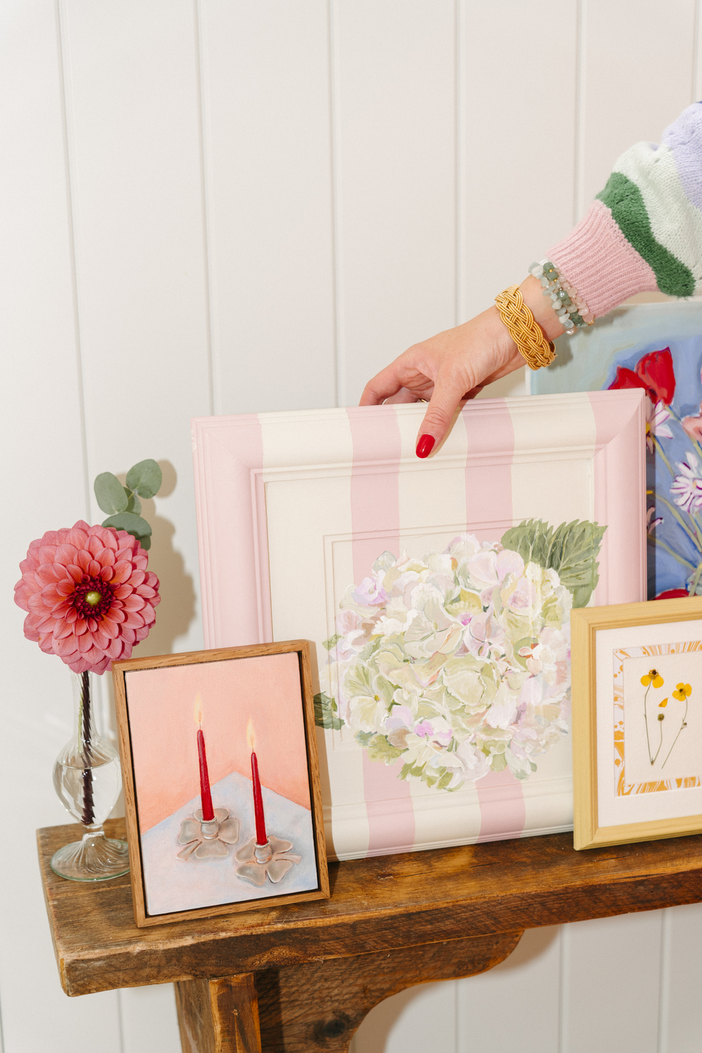 A close up various framed artworks by Domenica Marland on a wooden console table.