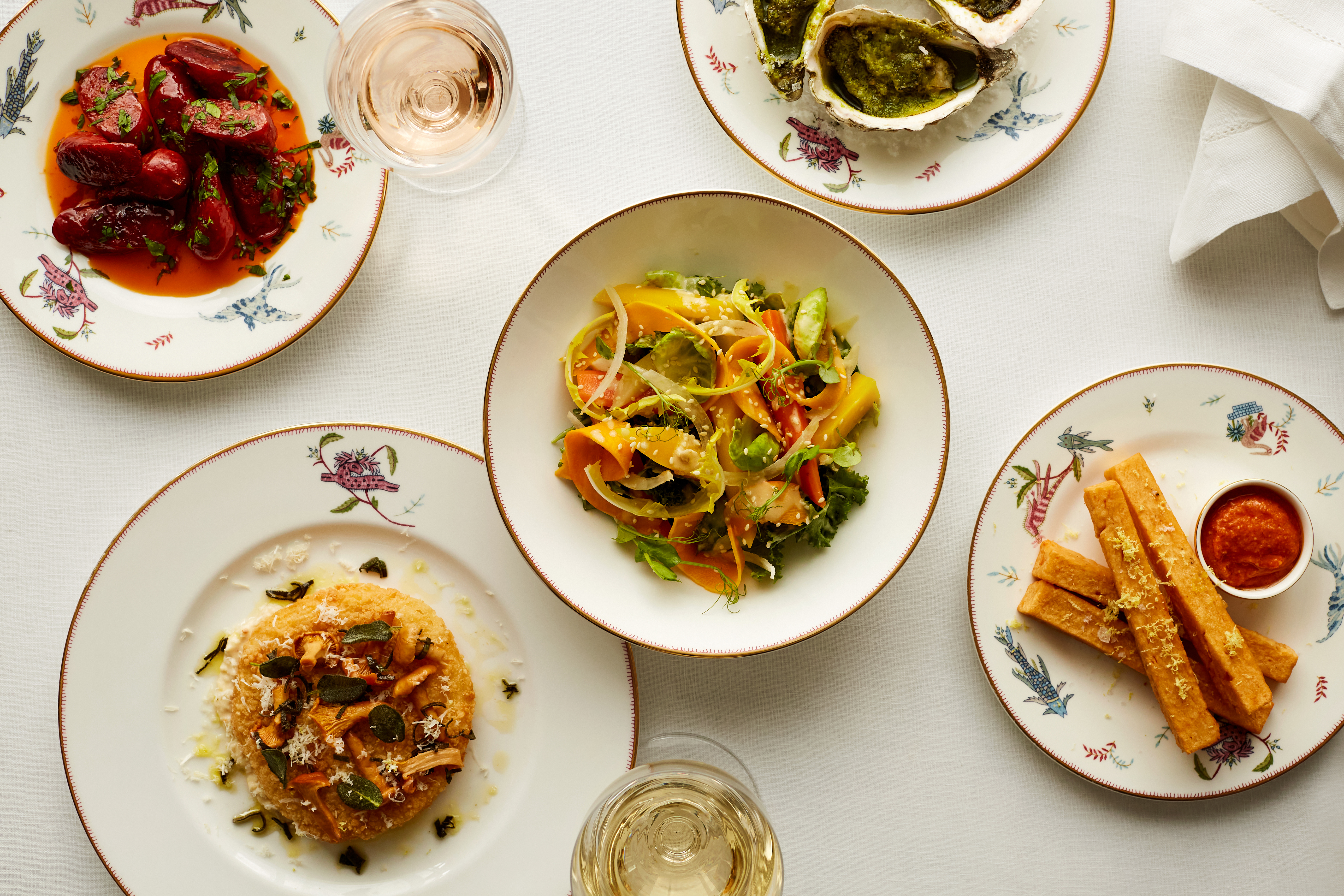 Bar food shot from above on a table at Oscar. Plates of salad, risotto, polenta, chorizo and oysters