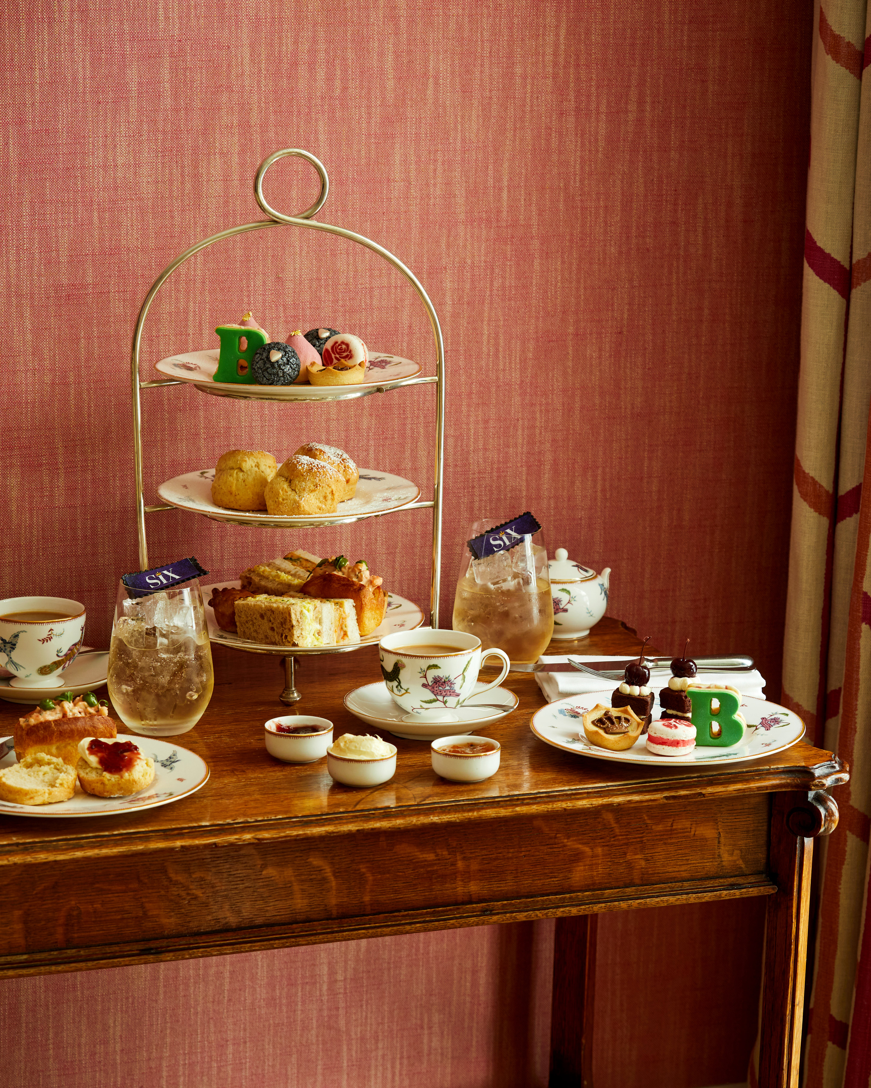 An image of the whole Afternoon Tea Set up with the cakes, sandwiches and cocktails for the Six: The Musical Afternoon Tea at Refuel, Soho Hotel.