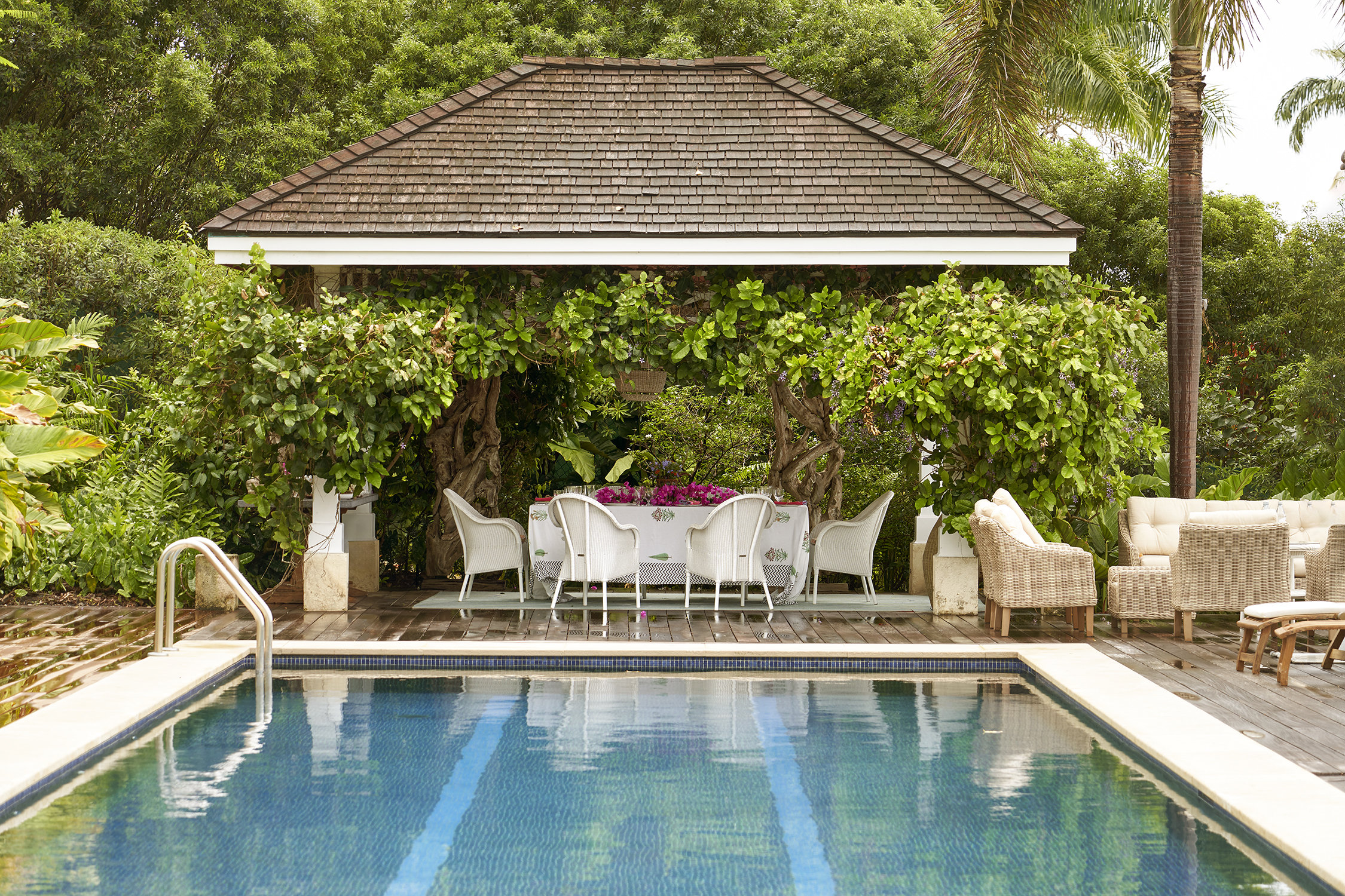 An image from the end of the pool of the terrace at the side of the pool used for dining. At Rossferry, the Caribbean property manged by Firmdale.