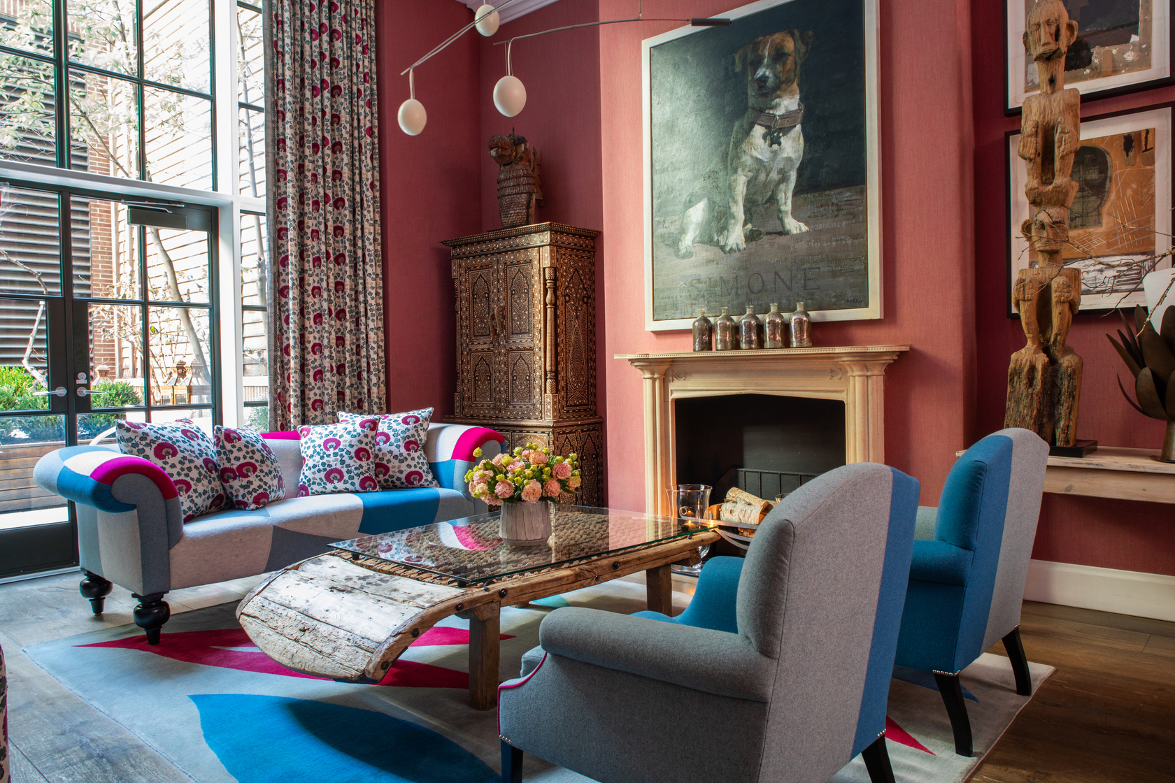 Diagonal shot of seating area around the fireplace the drawing room at Crosby Street Hotel.
