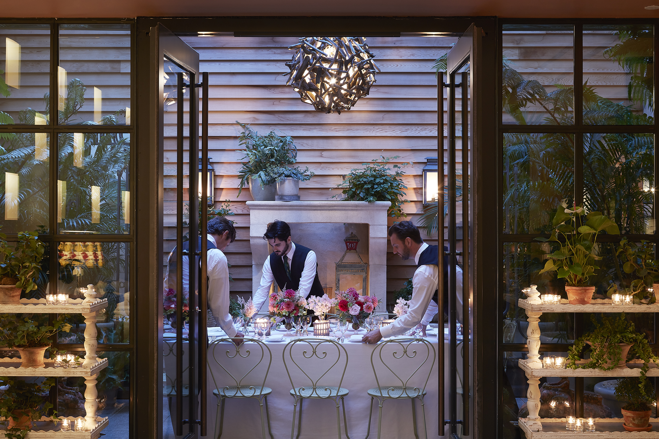 Long dining tables set-up and waiters in the Orangery private events room at the Whitby Hotel